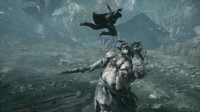 A huge bare-chested foe fills the foreground as a swordsman leaps behind him.